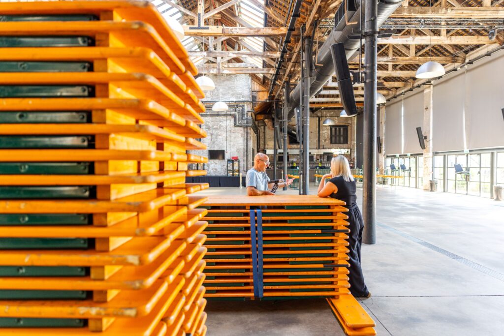 Work Beyond Walls setting up their space with large orange tables