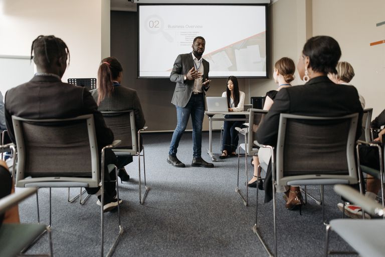 Diverse group attending a AI Upskilling training with a presenter and screen display.