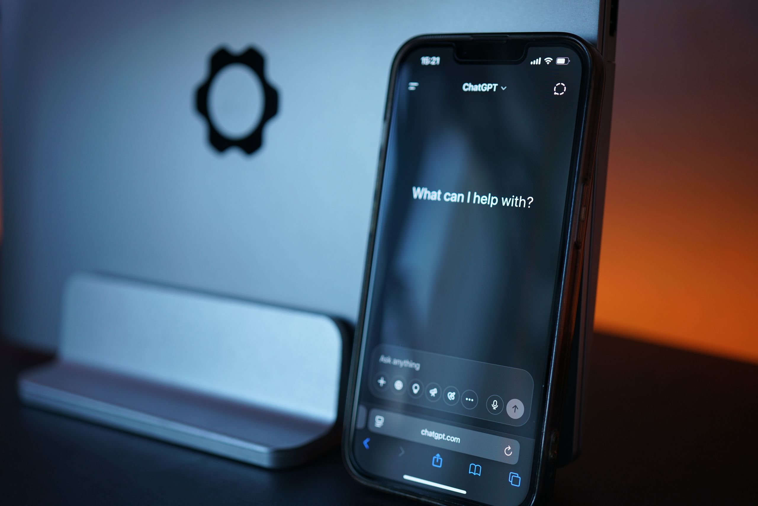 Close-up of a smartphone with AI chat interface, saying 'how can I help' to symbolise workplace wellbeing shifting with technology.