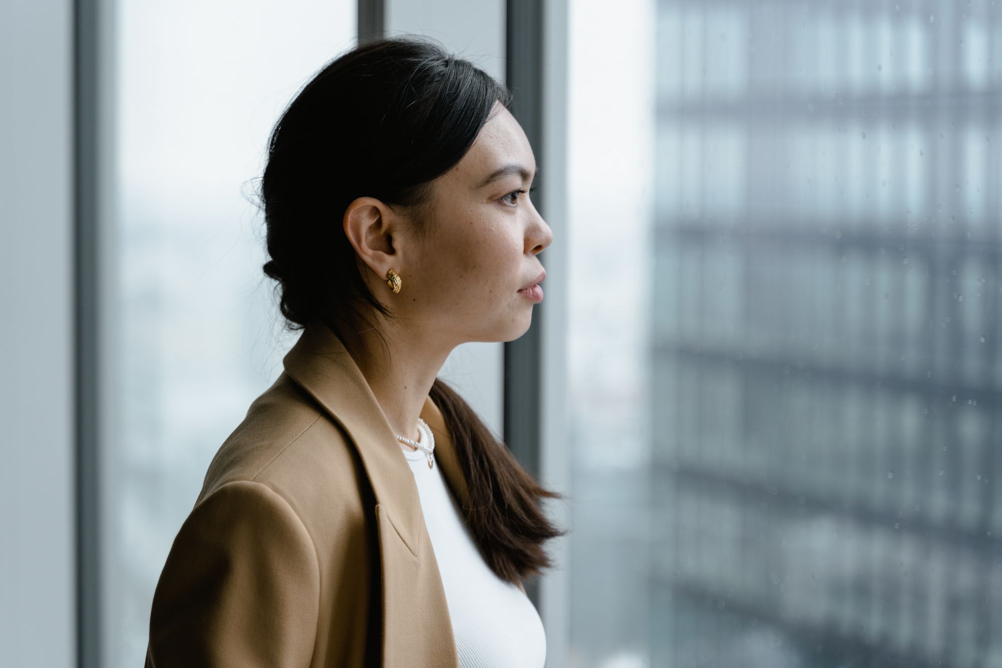 Woman looking out of an office window, employer mental health support